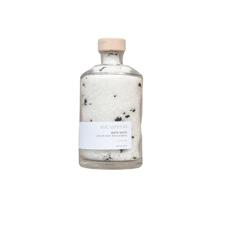 an elegant glass bottle with wood lid and a white label with the Sealuxe logo on it and reads Eucalyptus bath salts