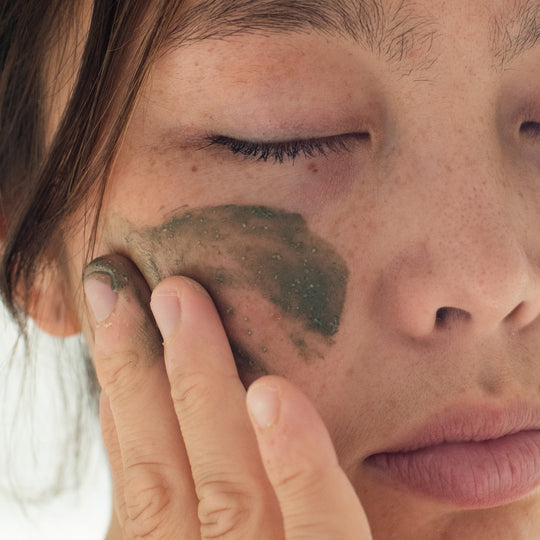 testing a seaweed mask on face and hand