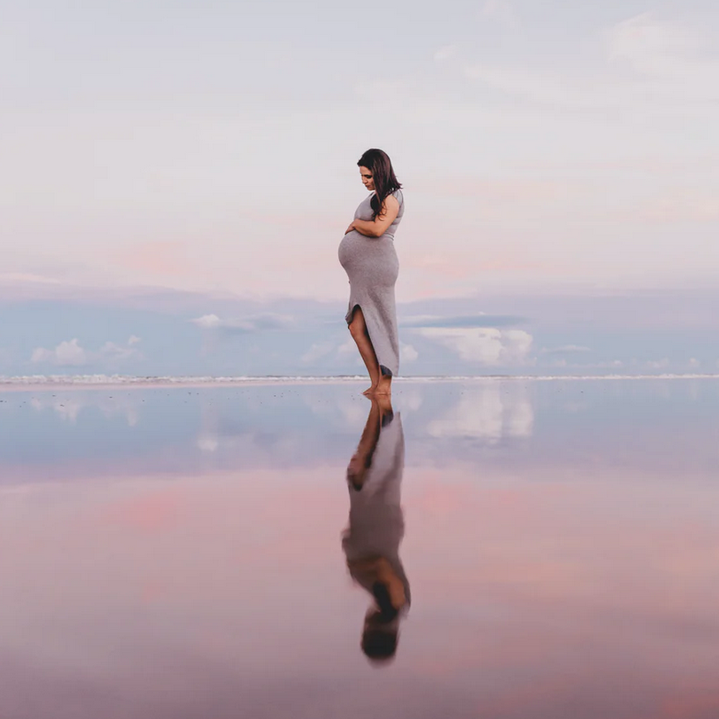 pregnant woman walking on the beach