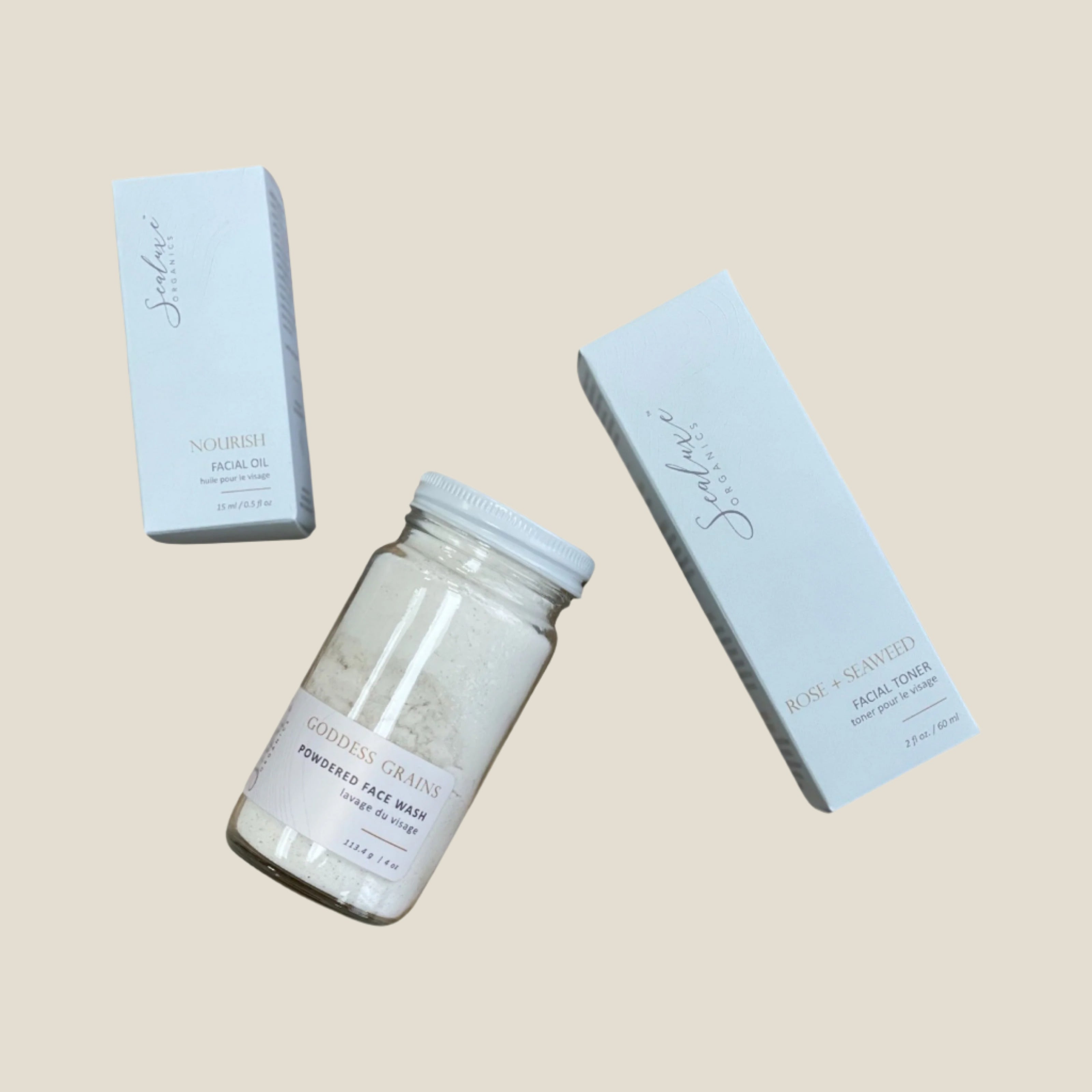 Three skincare products from Sealuxe, including a facial polish, facial oil, and toner, packaged in white containers with clear labels.