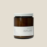 Brown candle jar with white lid and label on a light gray background