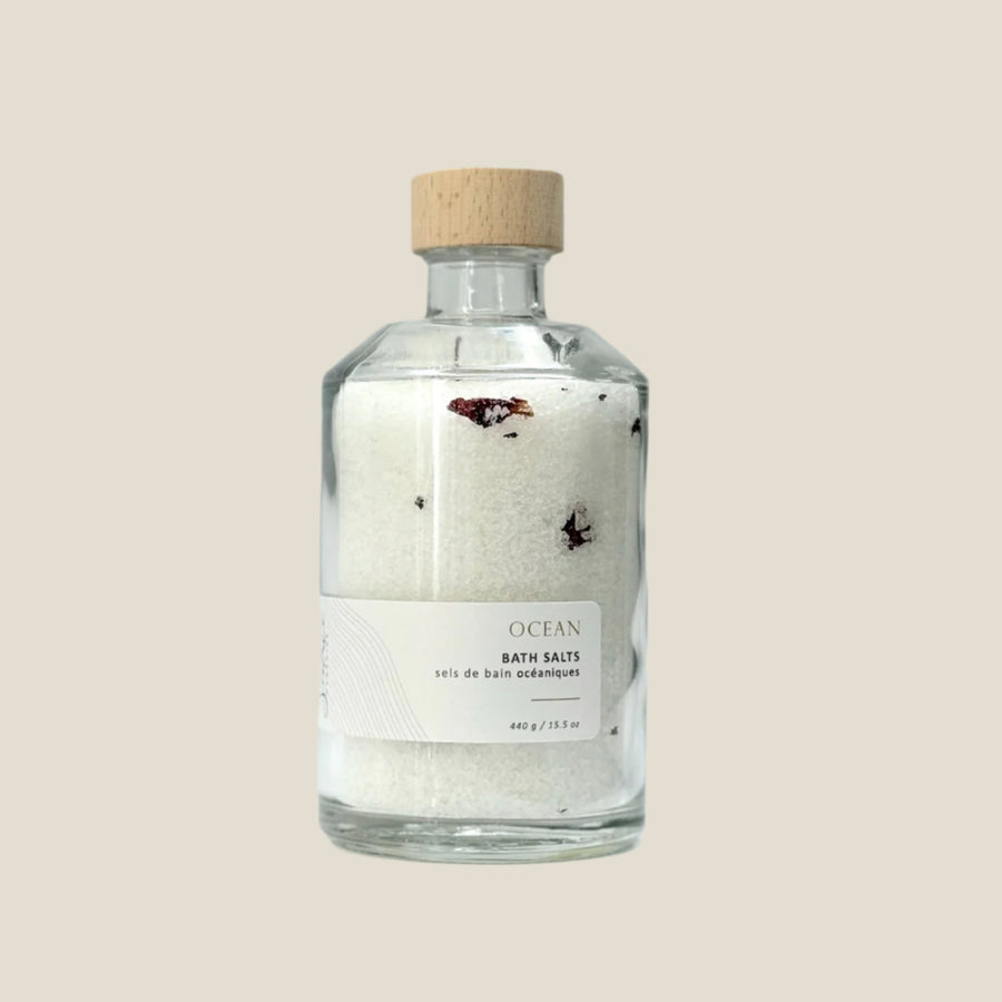 Bottle of Ocean Bath Salts with a wooden cap on a light gray background