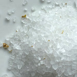 Close-up of white sea salt crystals on a white background