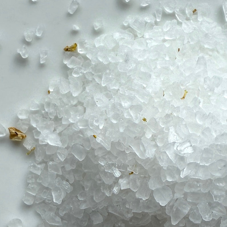 Close-up of white sea salt crystals on a white background
