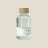 Bottle of bubble bath labeled 'Eucalyptus' with a wooden cap on a light gray background
