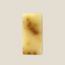 Rectangular bar of soap with a brown spot on a white background