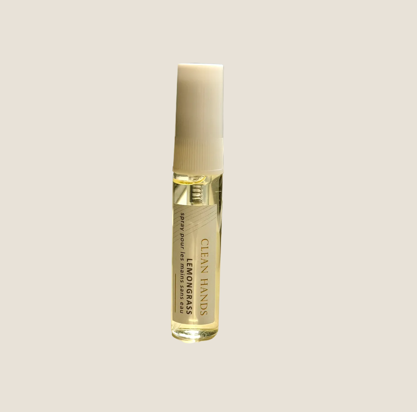 A small cylindrical roll-on bottle labeled 'CLEAN HANDS' and 'LEMONGRASS' stands on a windowsill with natural sunlight and a blurred window view in the background.