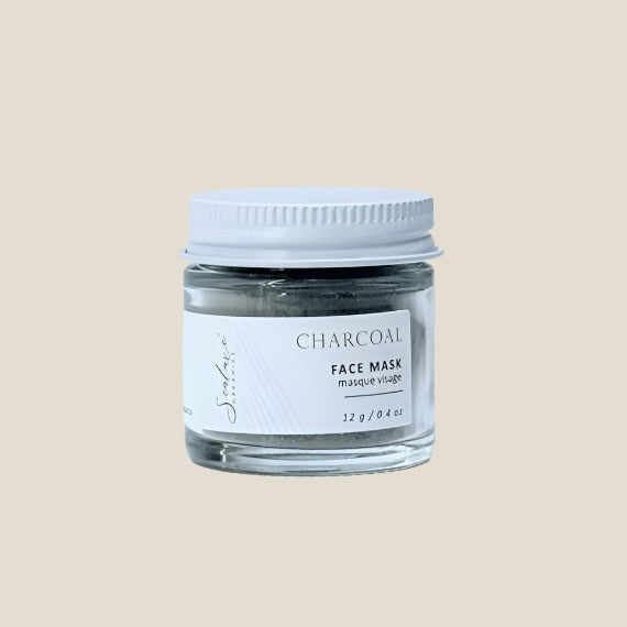 Jar of charcoal face mask with a white lid on a light gray background
