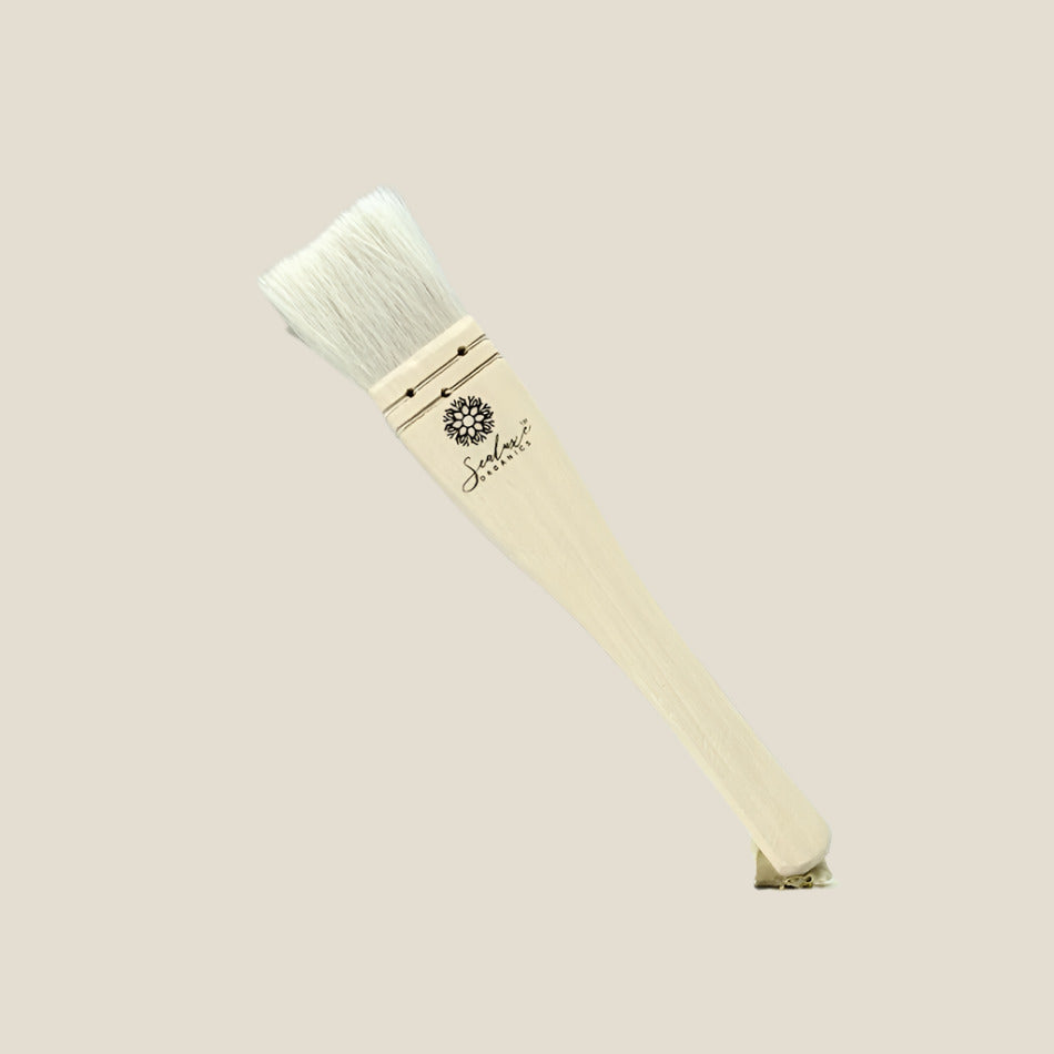 Paintbrush with wooden handle and white bristles on a light gray background