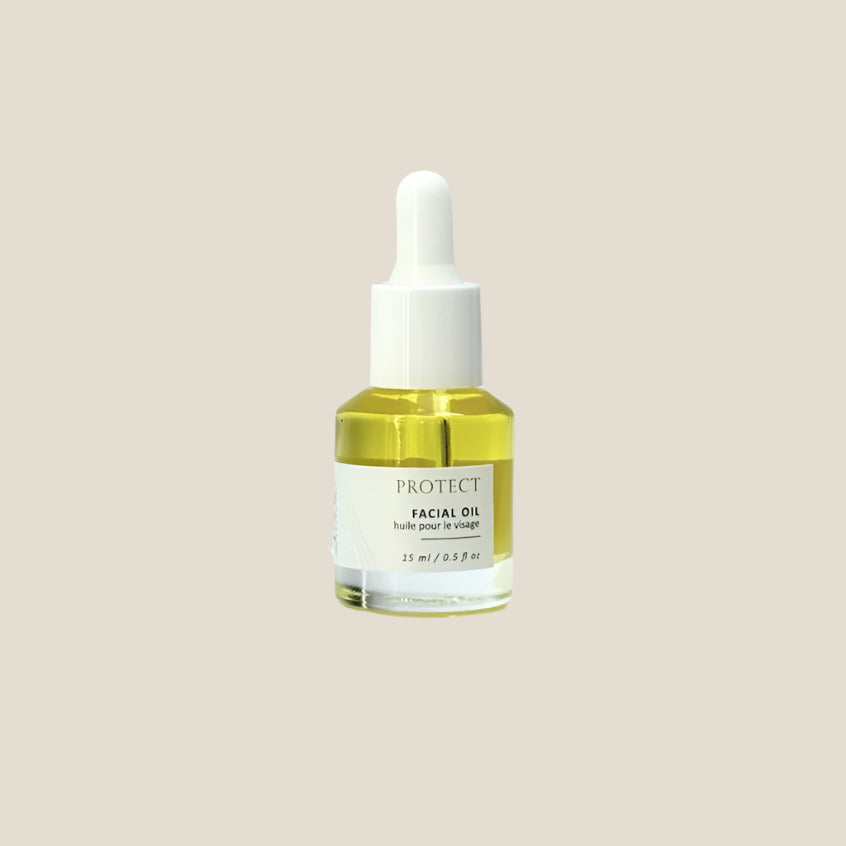 Facial oil dropper bottle with a white cap on a light gray background