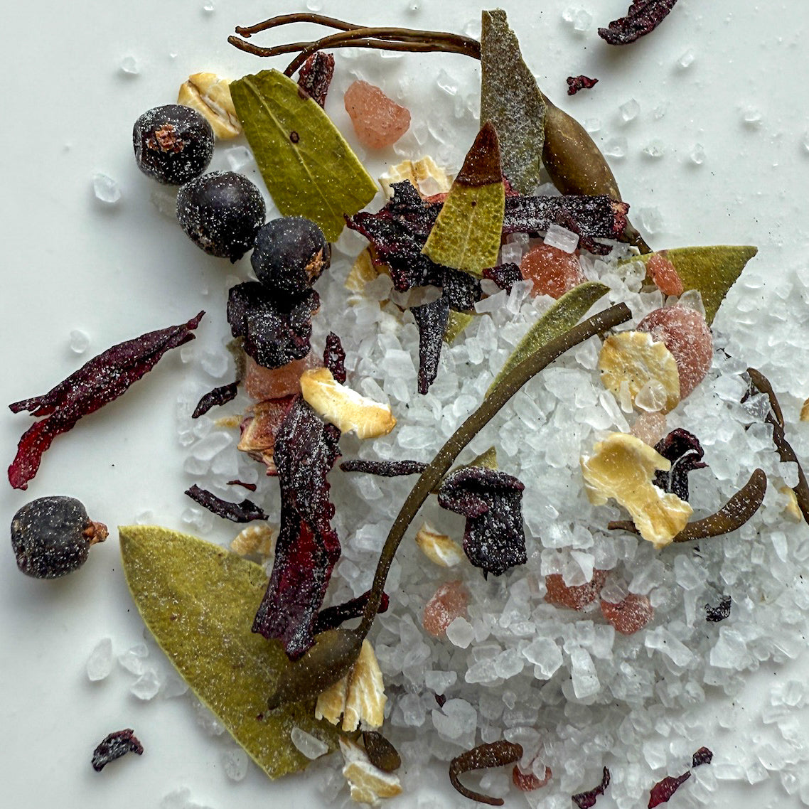 Seaweed and botanicals on a bed of salt with a white background