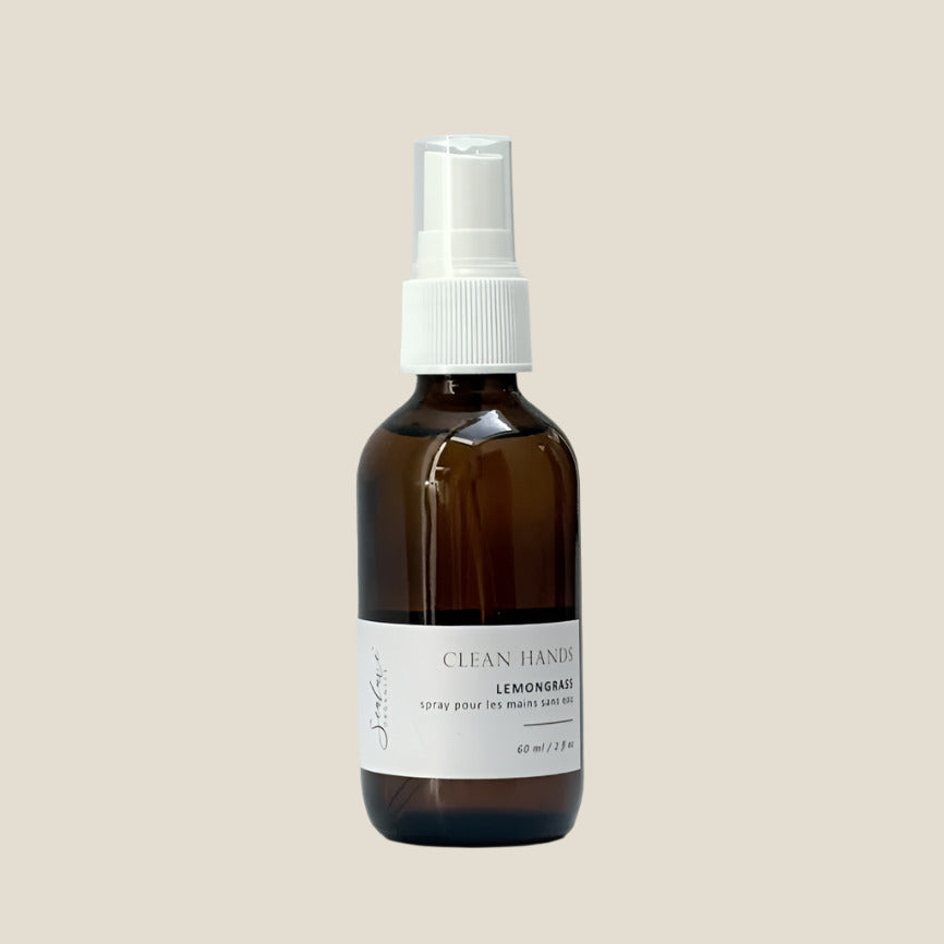 A bottle of Clean Hands - Purifying Hand Cleaner with a lemongrass scent, featuring a clear amber glass container and a white spray nozzle.