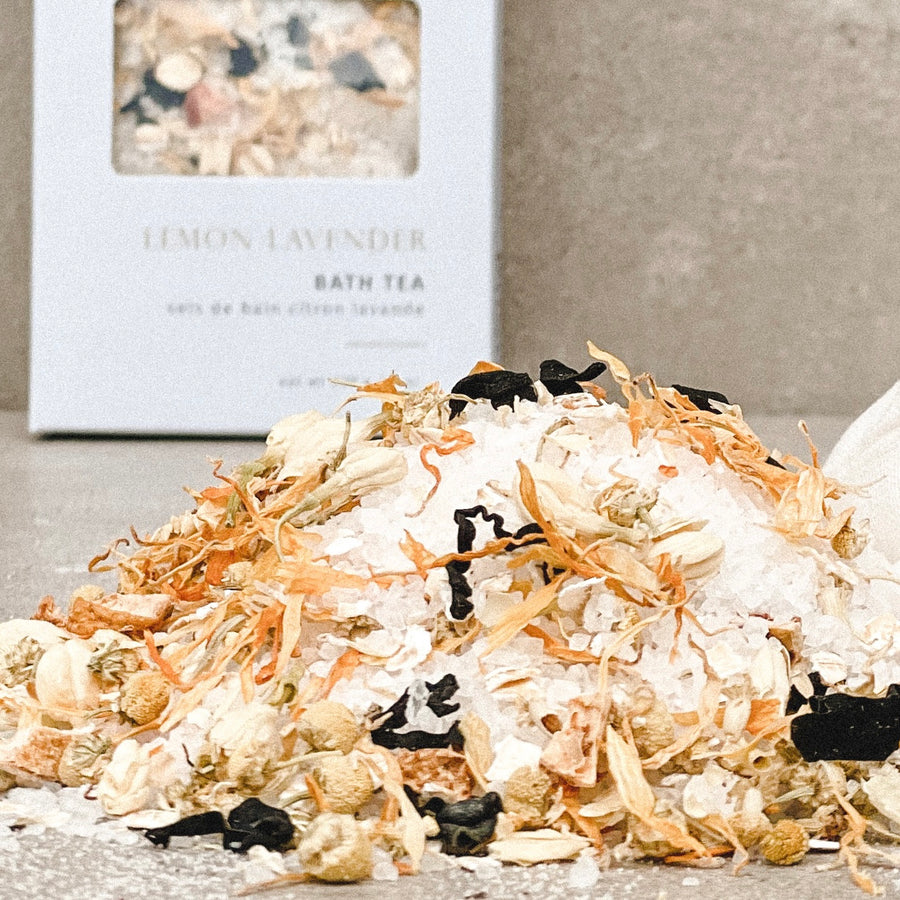 A pile of sea salts, seaweed and yellow botanicals with a muslin bag and a blurred Sealuxe blue box in the background