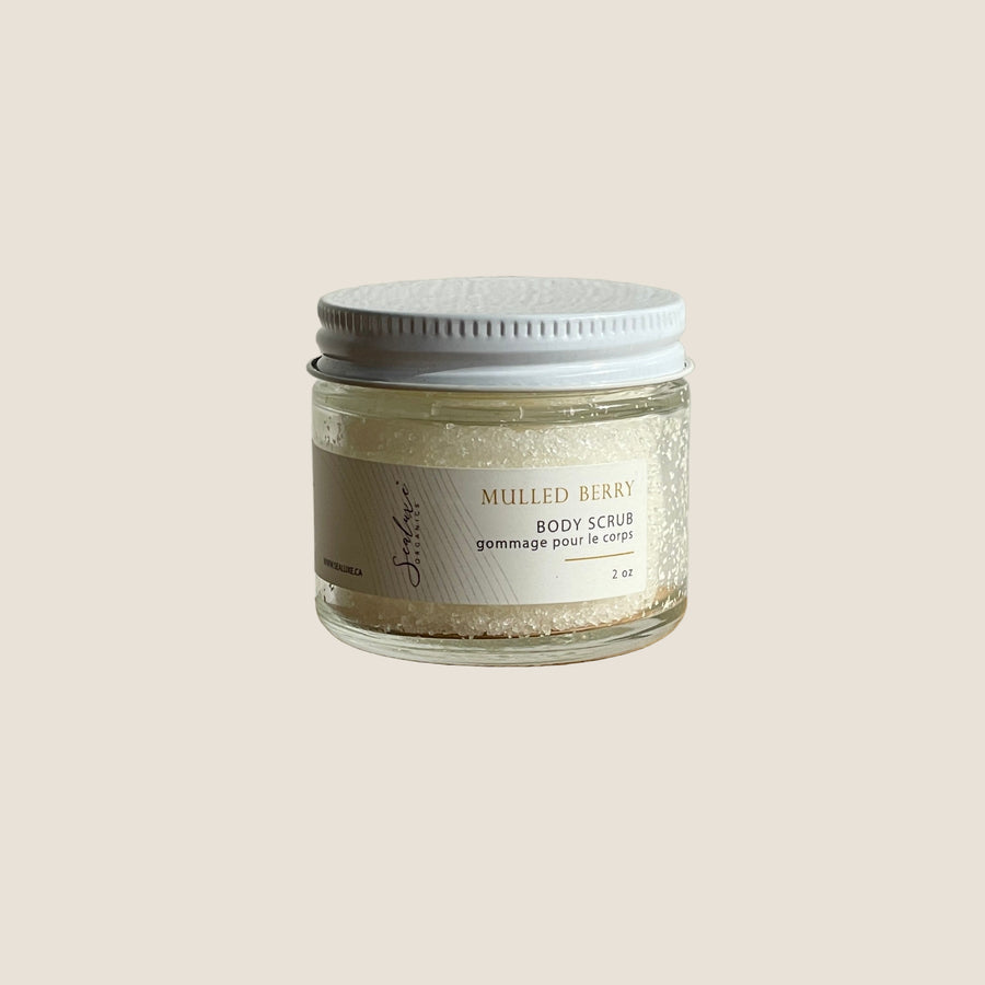 Jar of mulled berry body scrub on a wooden surface with a white background