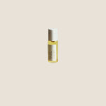 Small bottle of facial oil on a wooden surface with a white background