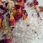 Close-up of sea salt with dried flowers on a white background