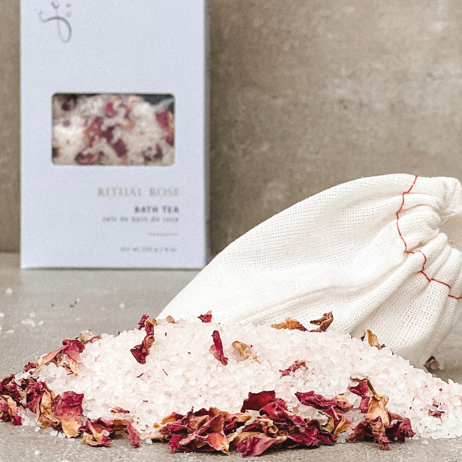 pink sea salt piles with rose petals and a cloth bag with a sealuxe logo