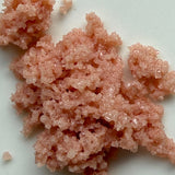 Close-up of pinkish-orange granular substance on a white background