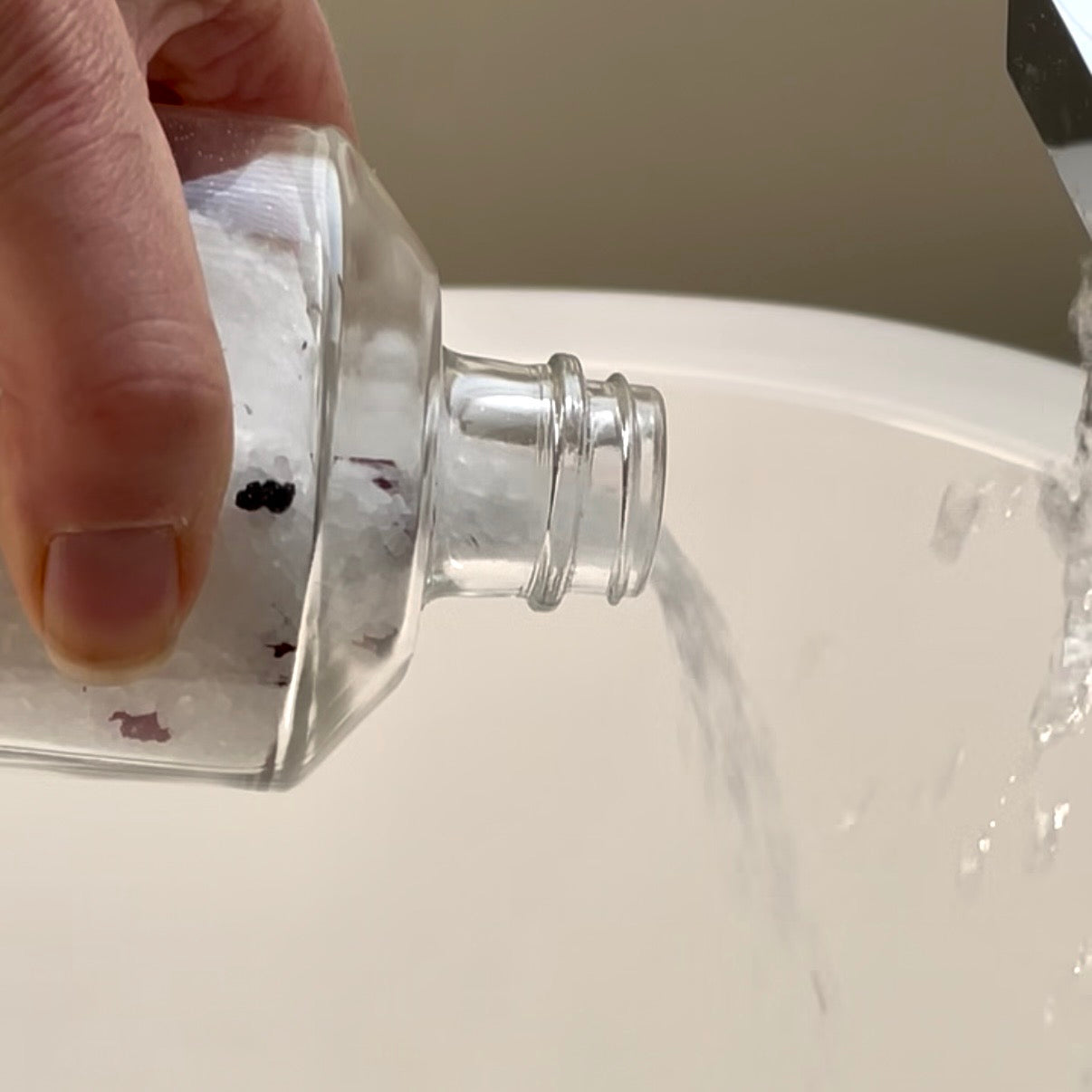 Sealuxe bath salts being poured into a filled bathtub
