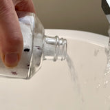 Sealuxe bath salts being poured into a filled bathtub