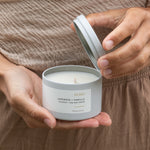 Hand holding an open Sealuxe Echo candle jar with the lid off