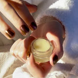 Fingers applying lip balm to lips