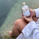Hands holding a jar of Sealuxe Forest Bathing bath salts