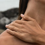 Close-up of hands massaging Sealuxe body oil into neck and shoulder skin — hydrating body oil in use