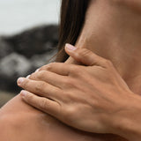 Close-up of hands massaging Sealuxe body oil into neck and shoulder skin — hydrating body oil in use