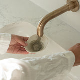 Mixing Sealuxe facial mask powder with water in hands