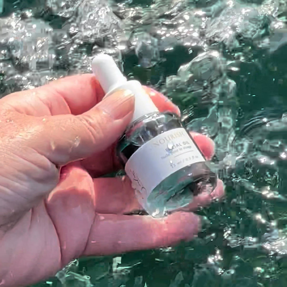 Sealuxe Nourish facial oil bottle near water