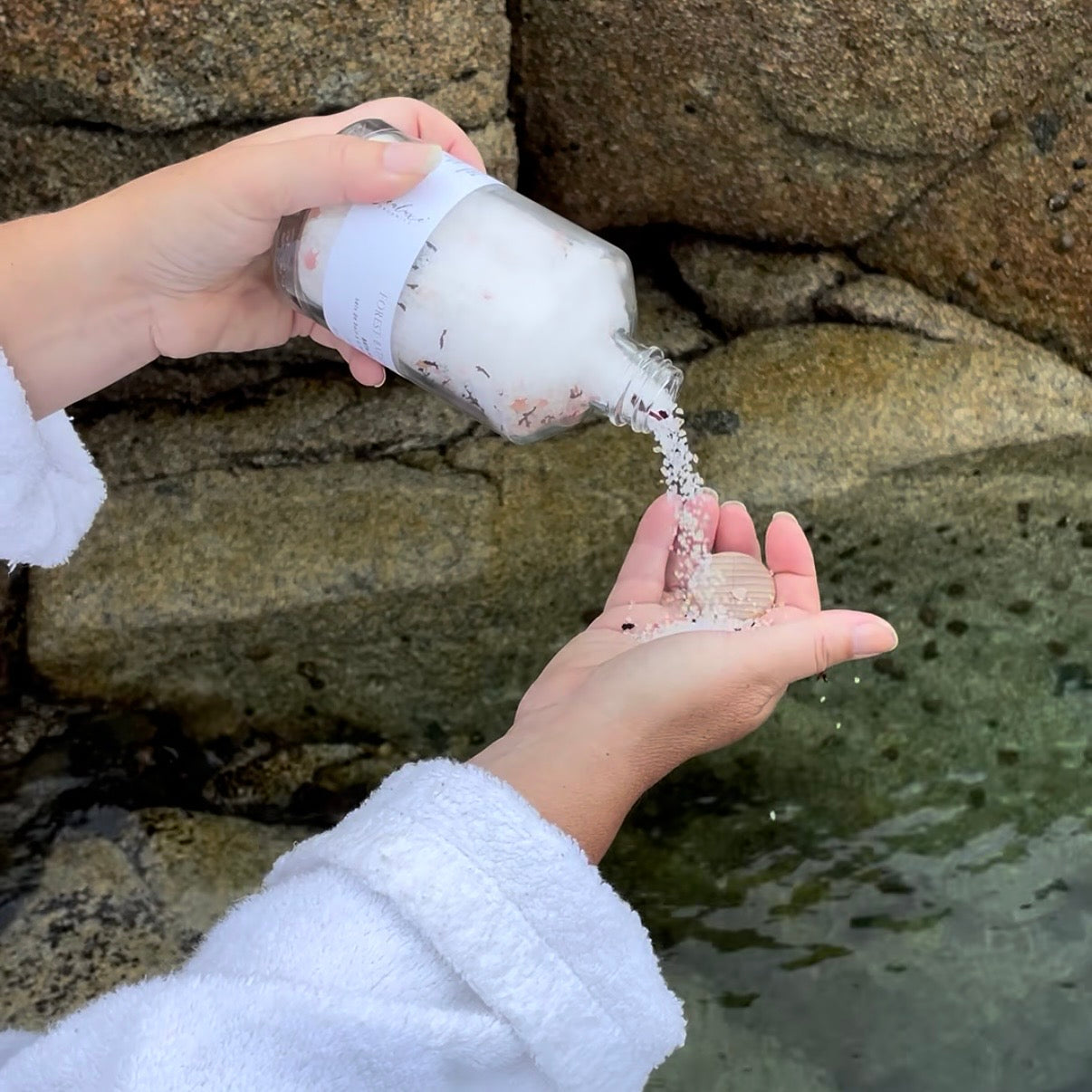 Pouring Sealuxe Lavender Vanilla bath salts into a bath