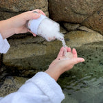 Pouring Sealuxe Lavender Vanilla bath salts into a bath