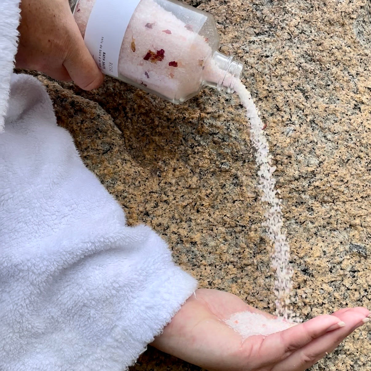 Pouring Sealuxe Rose bath salts into a bath