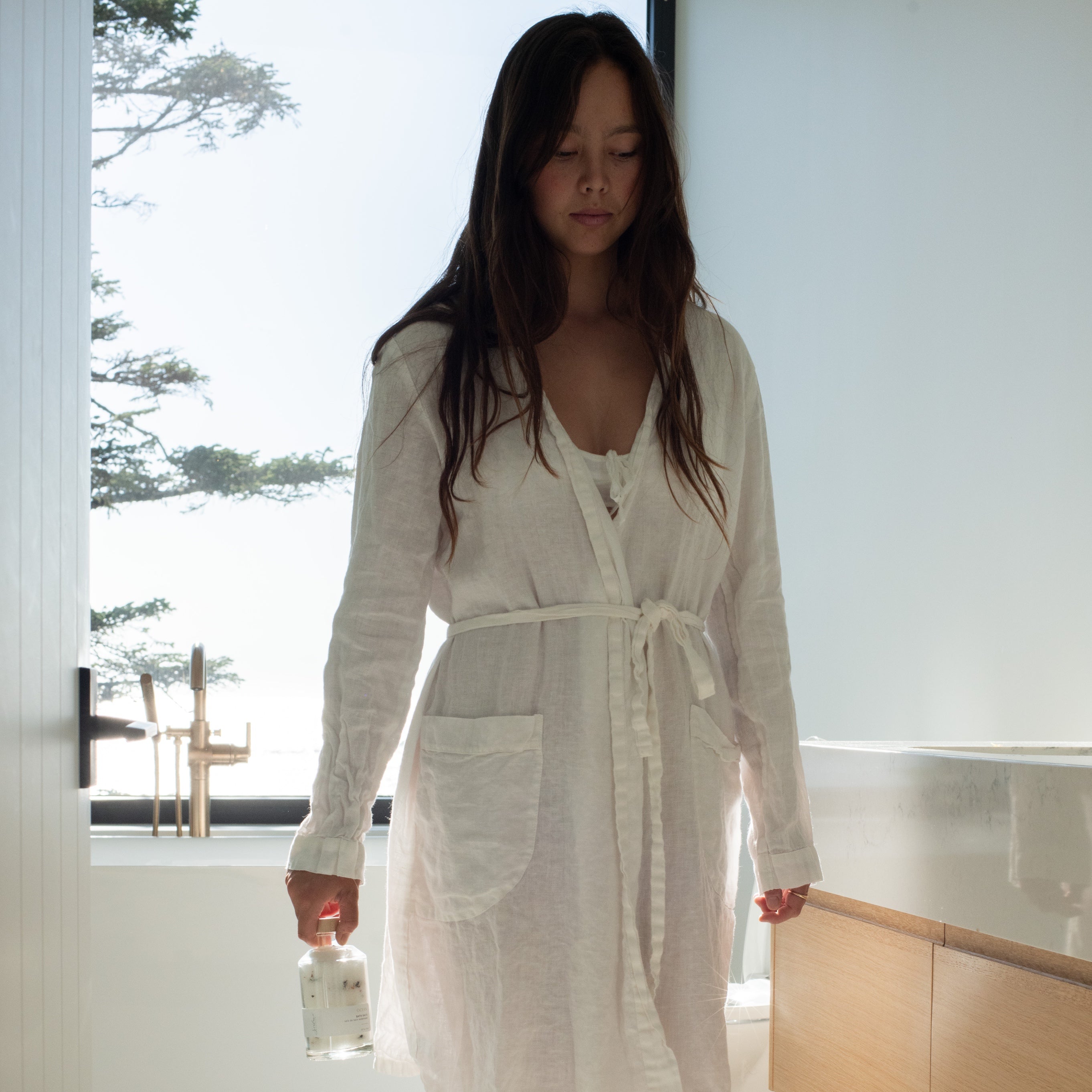 Woman in a bathroom with Sealuxe bath salts
