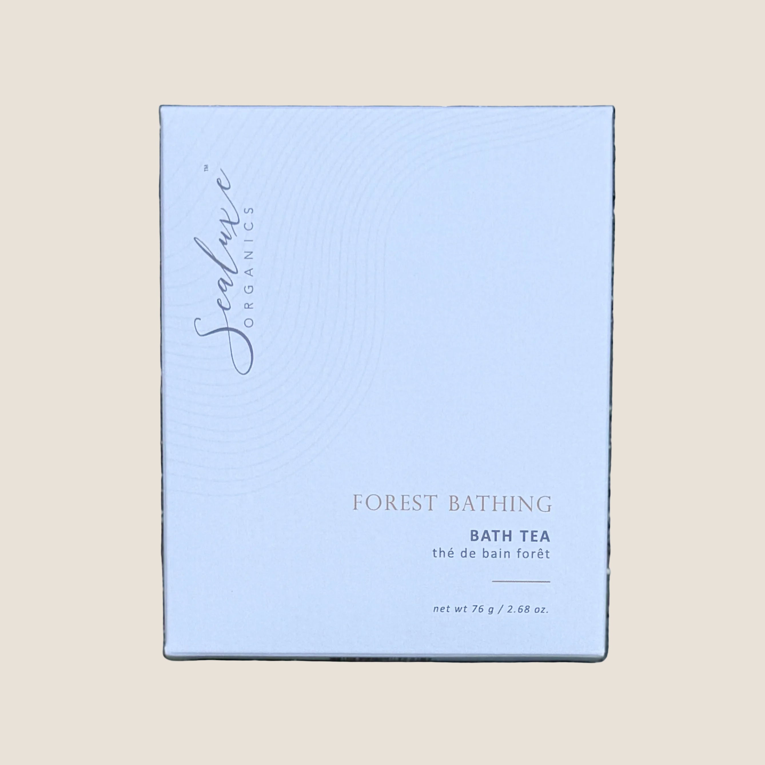 A square white box of Sealuxe Organics Forest Bathing Bath Tea. The box features elegant gold and dark gray text and subtle concentric wave patterns.