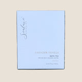 A rectangular box of Sealuxe Lavender Vanilla Bath Tea. The box is a very pale lavender-blue with black script branding and black text, including 'LAVENDER VANILLA BATH TEA' and 'net wt 76 g / 2.