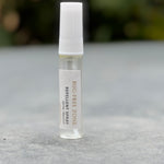 Bug-Free Zone repellent spray bottle on a gray surface with a blurred natural background