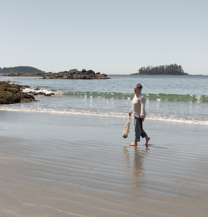 Tanya Droege walking along the westcoast beach in Tofino picking up plastic to keep the oceans clean for Ripple effect beach cleanups