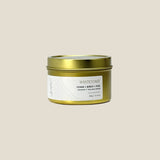 Gold candle tin with a white label on a light gray background